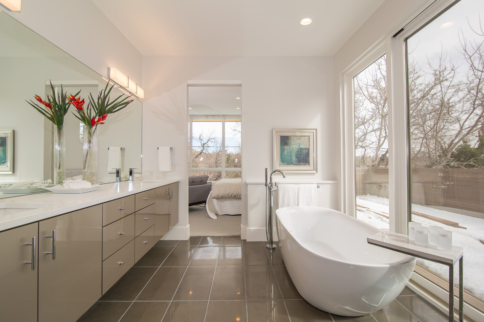 Пример оригинального дизайна: главная ванная комната среднего размера в стиле модернизм с отдельно стоящей ванной, белыми стенами, душем в нише, полом из цементной плитки, бежевым полом, душем с распашными дверями и белой столешницей