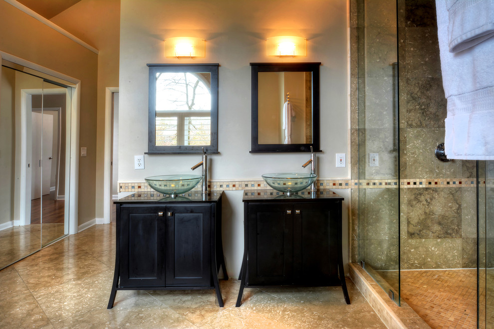 Large trendy master beige tile and stone tile limestone floor double shower photo in Charlotte with a vessel sink, raised-panel cabinets, black cabinets, granite countertops, a hot tub, a two-piece toilet and beige walls