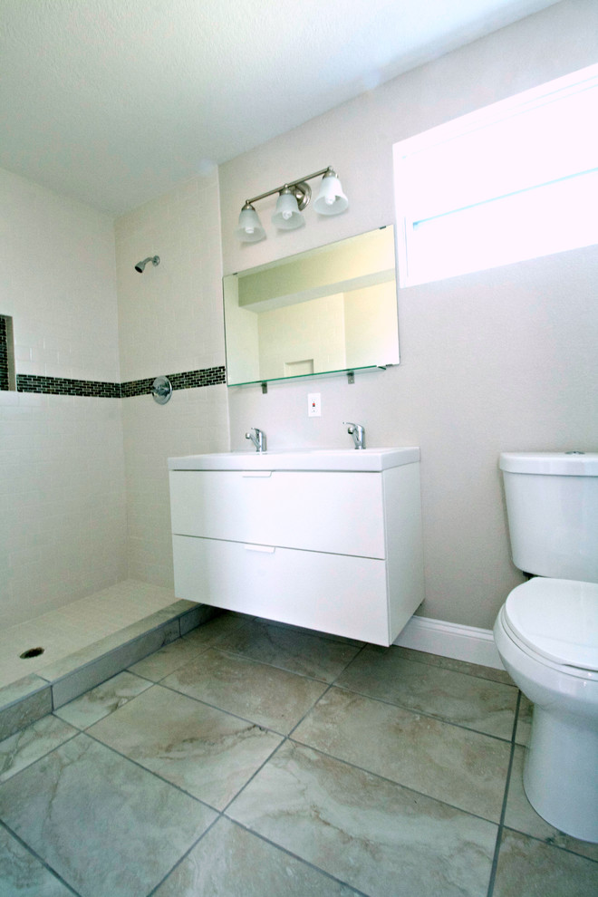 Inspiration pour une salle de bain principale vintage de taille moyenne avec un lavabo intégré, un placard à porte plane, des portes de placard blanches, un plan de toilette en surface solide, une douche ouverte, WC à poser, un mur blanc et un sol en carrelage de céramique.
