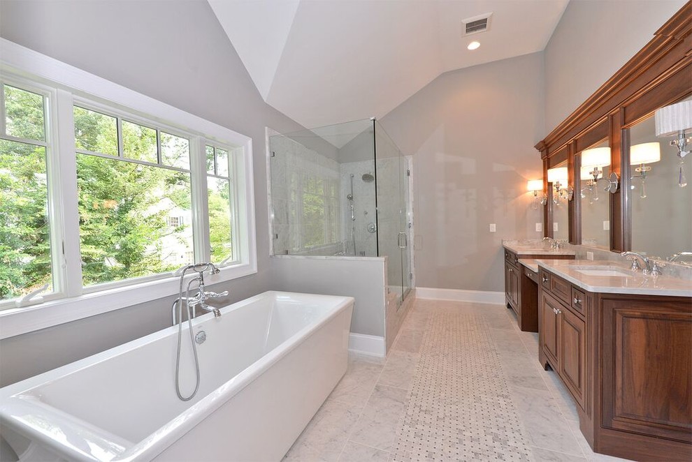 Идея дизайна: огромная главная ванная комната в стиле кантри с фасадами с выступающей филенкой, темными деревянными фасадами, отдельно стоящей ванной, угловым душем, унитазом-моноблоком, бежевой плиткой, черной плиткой, черно-белой плиткой, коричневой плиткой, серой плиткой, разноцветной плиткой, белой плиткой, керамогранитной плиткой, серыми стенами, мраморным полом, врезной раковиной и мраморной столешницей