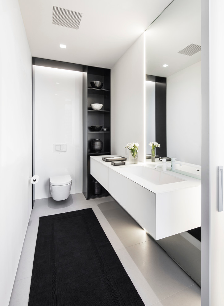 Idéer för ett modernt badrum, med en vägghängd toalettstol och vita väggar