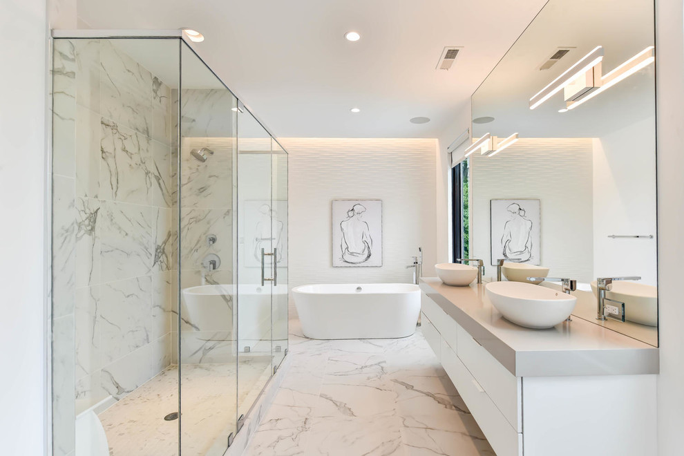 Inredning av ett modernt beige beige en-suite badrum, med släta luckor, vita skåp, ett fristående badkar, flerfärgad kakel, marmorkakel, vita väggar, marmorgolv, ett fristående handfat, flerfärgat golv och dusch med gångjärnsdörr