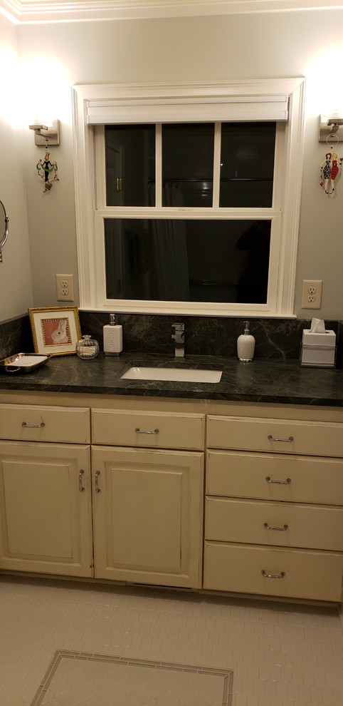 Klassisk inredning av ett litet turkos turkost badrum för barn, med luckor med upphöjd panel, skåp i slitet trä, ett badkar i en alkov, en dusch/badkar-kombination, en toalettstol med separat cisternkåpa, vit kakel, porslinskakel, gröna väggar, klinkergolv i porslin, ett undermonterad handfat, granitbänkskiva, vitt golv och dusch med duschdraperi