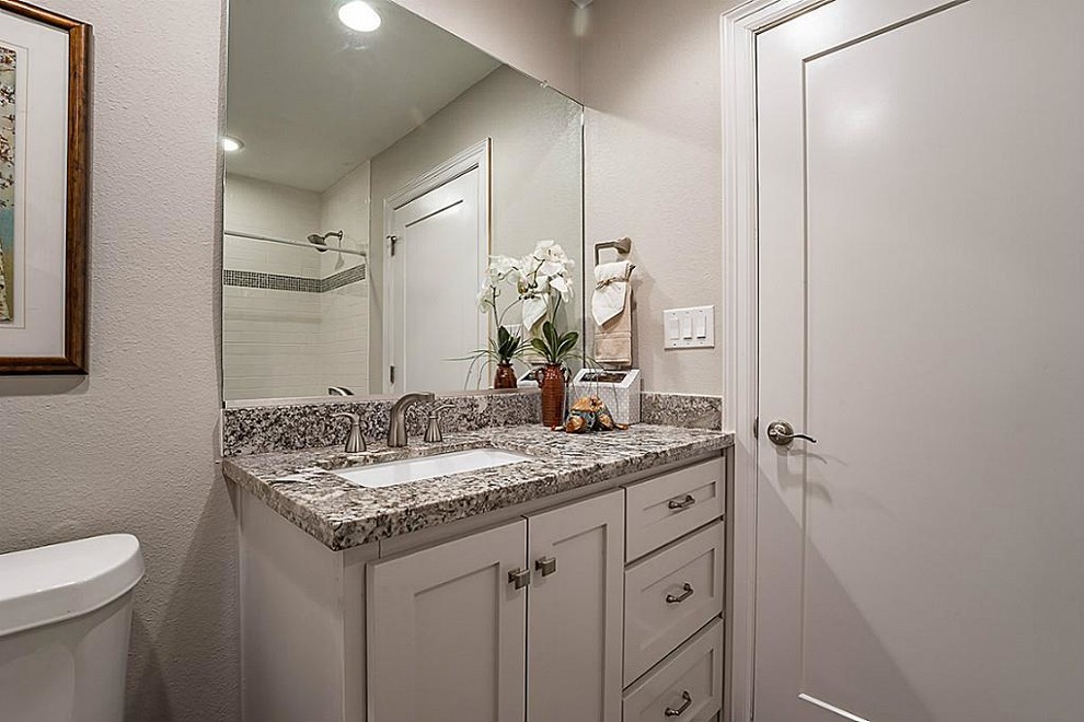 Inspiration för ett litet amerikanskt badrum med dusch, med skåp i shakerstil, vita skåp, ett badkar i en alkov, en dusch/badkar-kombination, en toalettstol med separat cisternkåpa, grå väggar, ett undermonterad handfat, granitbänkskiva och tunnelbanekakel