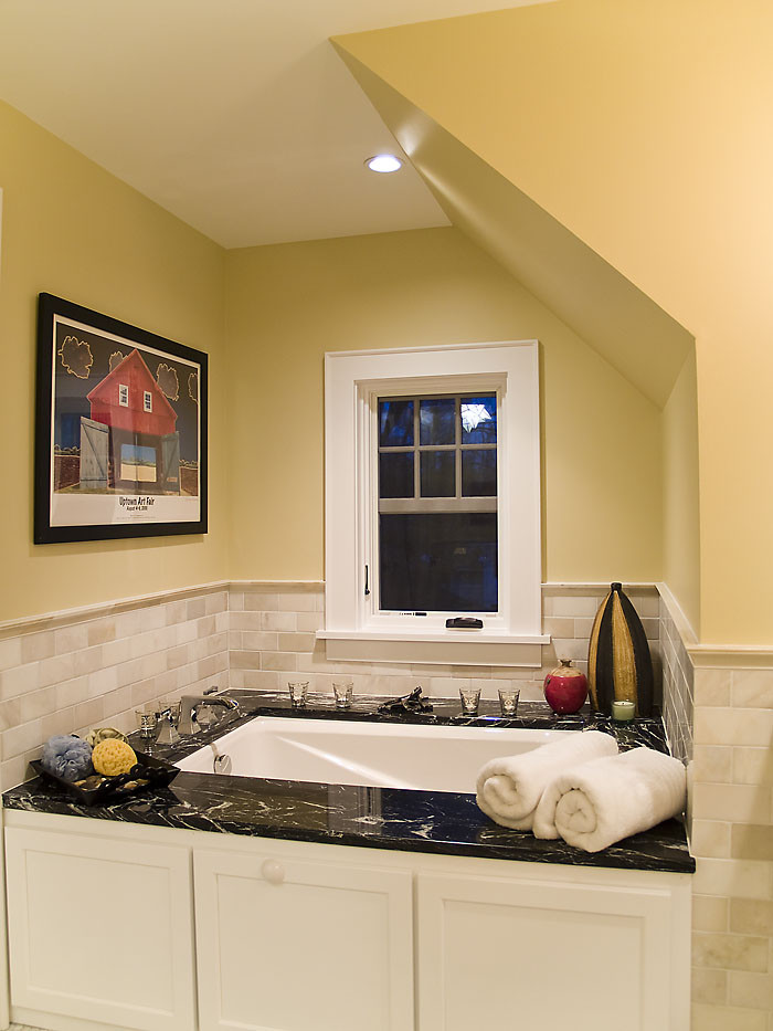Idee per una stanza da bagno design con vasca sottopiano, piastrelle beige, piastrelle di marmo, pareti gialle, pavimento con piastrelle a mosaico e pavimento multicolore