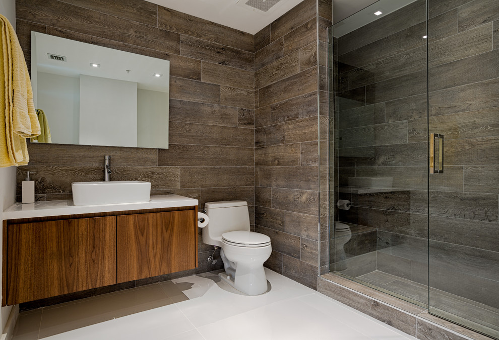 Design ideas for a contemporary bathroom in Miami with a vessel sink, flat-panel cabinets, dark wood cabinets, an alcove shower and a one-piece toilet.