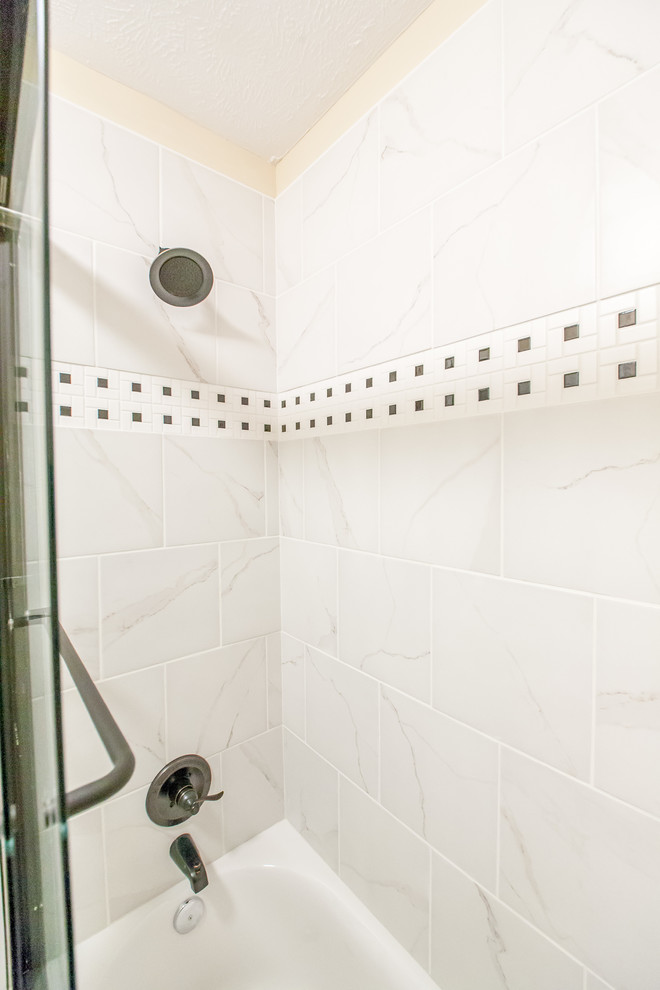 Photo of a traditional shower room bathroom in Nashville with raised-panel cabinets, a shower/bath combination, white tiles, ceramic tiles, beige walls and ceramic flooring.