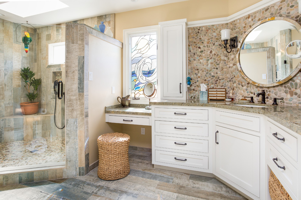 Example of a large beach style master multicolored tile and pebble tile multicolored floor corner shower design in Orange County with beaded inset cabinets, granite countertops, multicolored walls, a hinged shower door and multicolored countertops