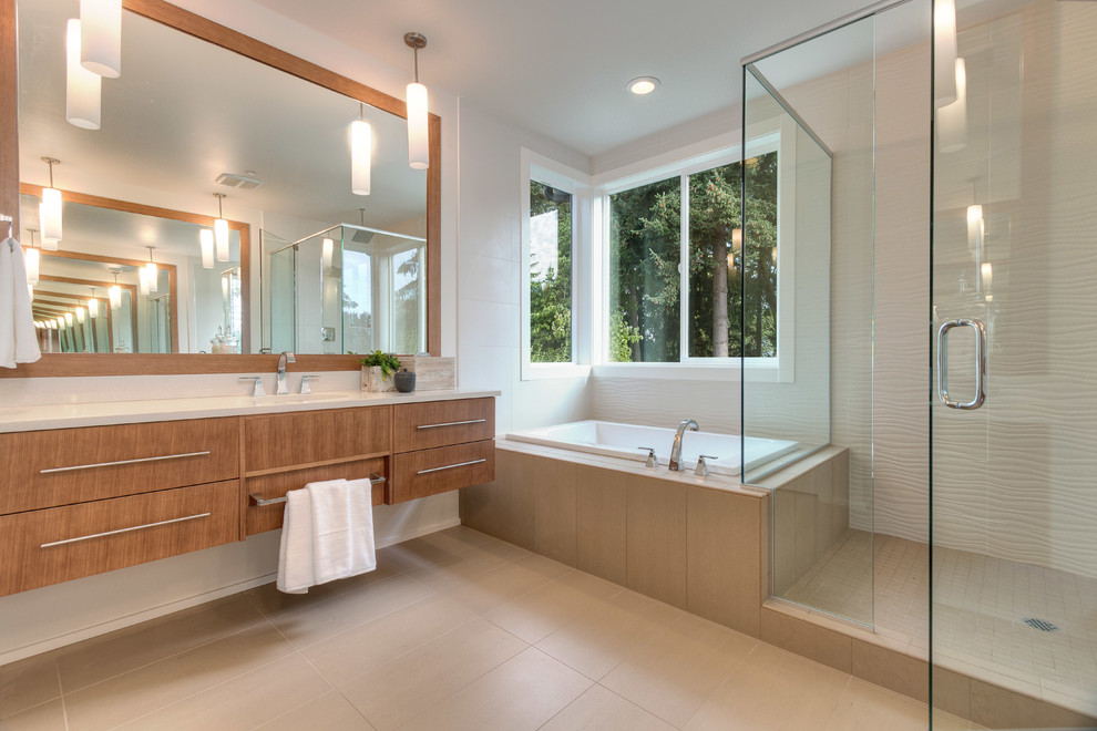 Contemporary ensuite bathroom in Seattle with flat-panel cabinets, medium wood cabinets, a built-in bath, a corner shower, beige tiles, multi-coloured walls, an integrated sink and a hinged door.