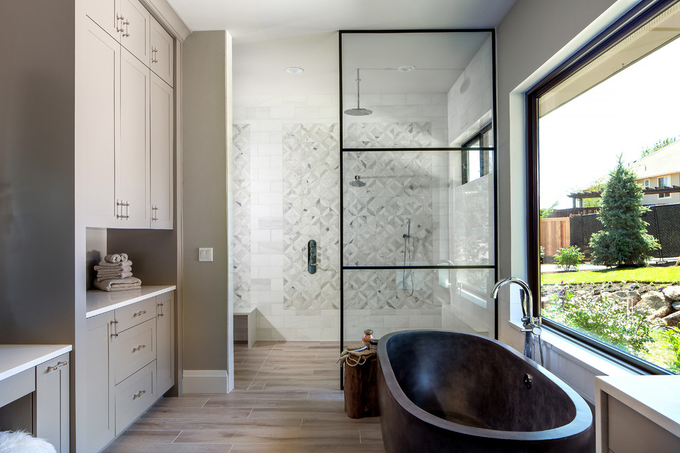 Idéer för stora lantliga vitt en-suite badrum, med skåp i shakerstil, ett fristående badkar, en öppen dusch, vit kakel, grå kakel, flerfärgad kakel, marmorkakel, klinkergolv i porslin, bänkskiva i kvarts, med dusch som är öppen, grå skåp, grå väggar och beiget golv
