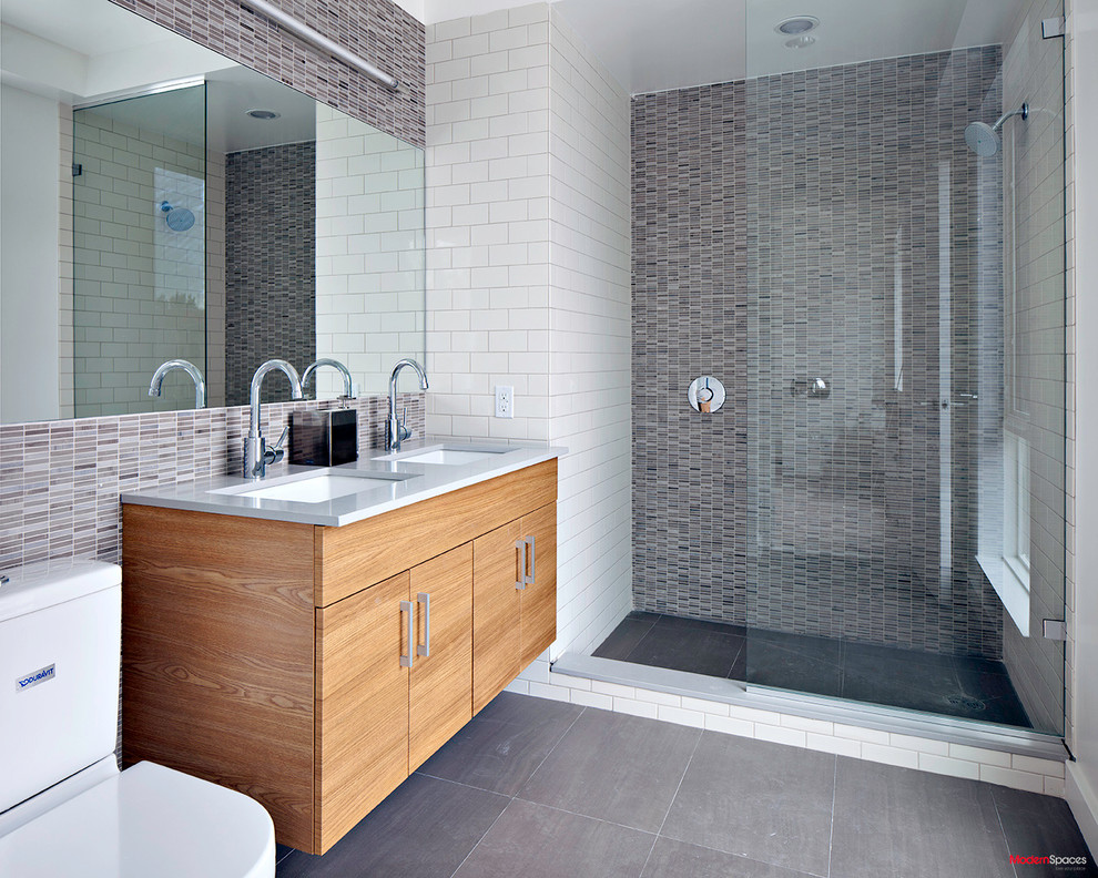 Inspiration for a modern gray tile bathroom remodel in New York with flat-panel cabinets, light wood cabinets and quartz countertops