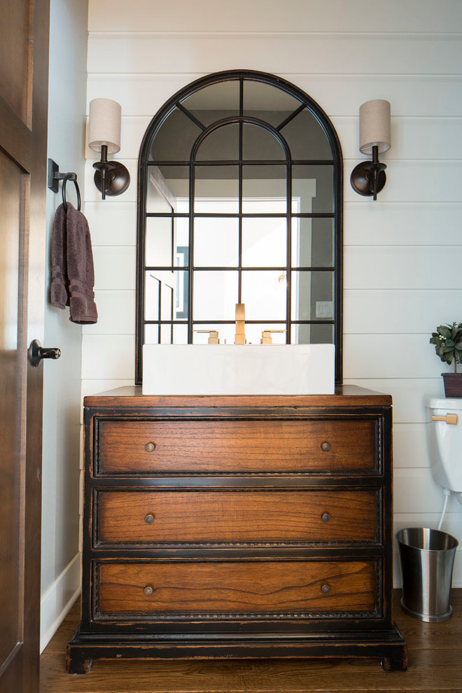 Cette image montre une petite salle de bain rustique en bois foncé avec un placard en trompe-l'oeil, WC séparés, un mur blanc, un sol en bois brun, une vasque et un plan de toilette en bois.