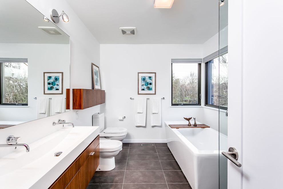 Mittelgroßes Modernes Badezimmer En Suite mit flächenbündigen Schrankfronten, hellbraunen Holzschränken, Einbaubadewanne, weißer Wandfarbe, Waschtischkonsole und Mineralwerkstoff-Waschtisch in Toronto