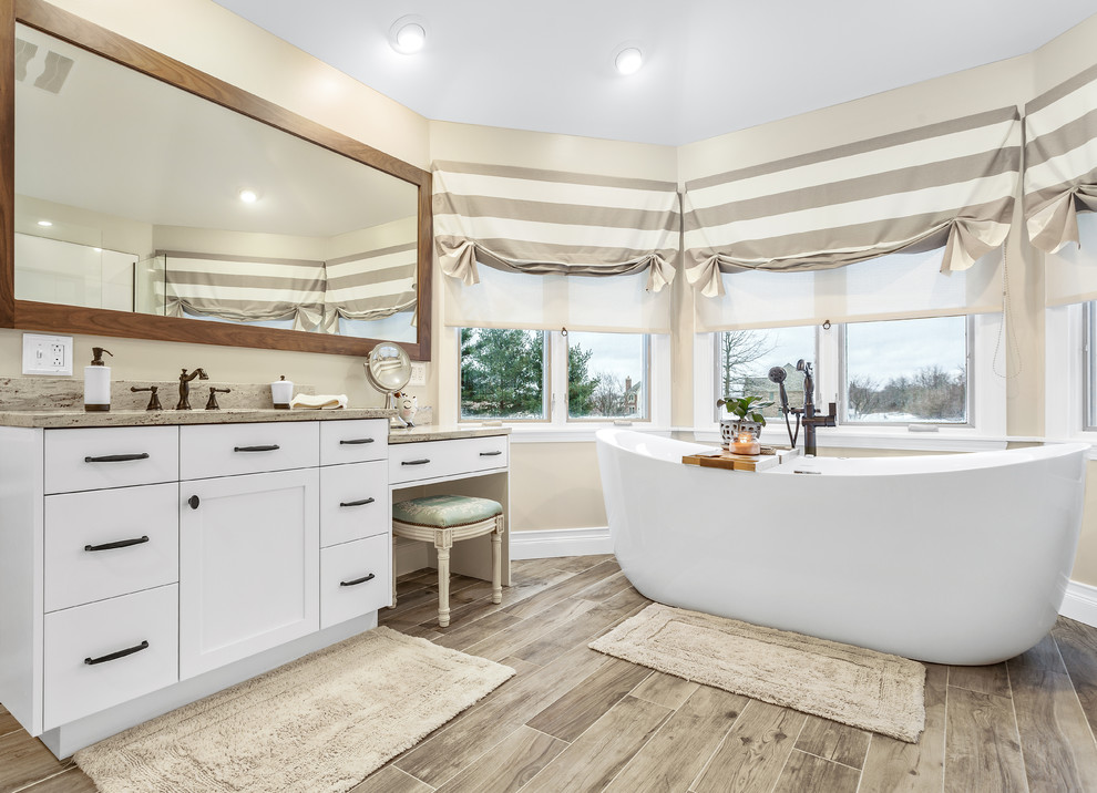 Inspiration for a large transitional master ceramic tile and gray floor bathroom remodel in Chicago with flat-panel cabinets, white cabinets, a one-piece toilet, beige walls, an undermount sink, granite countertops and beige countertops