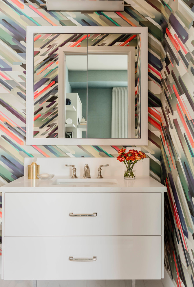 Foto di una stanza da bagno minimal con ante lisce, ante bianche, pareti multicolore, lavabo sottopiano e top bianco