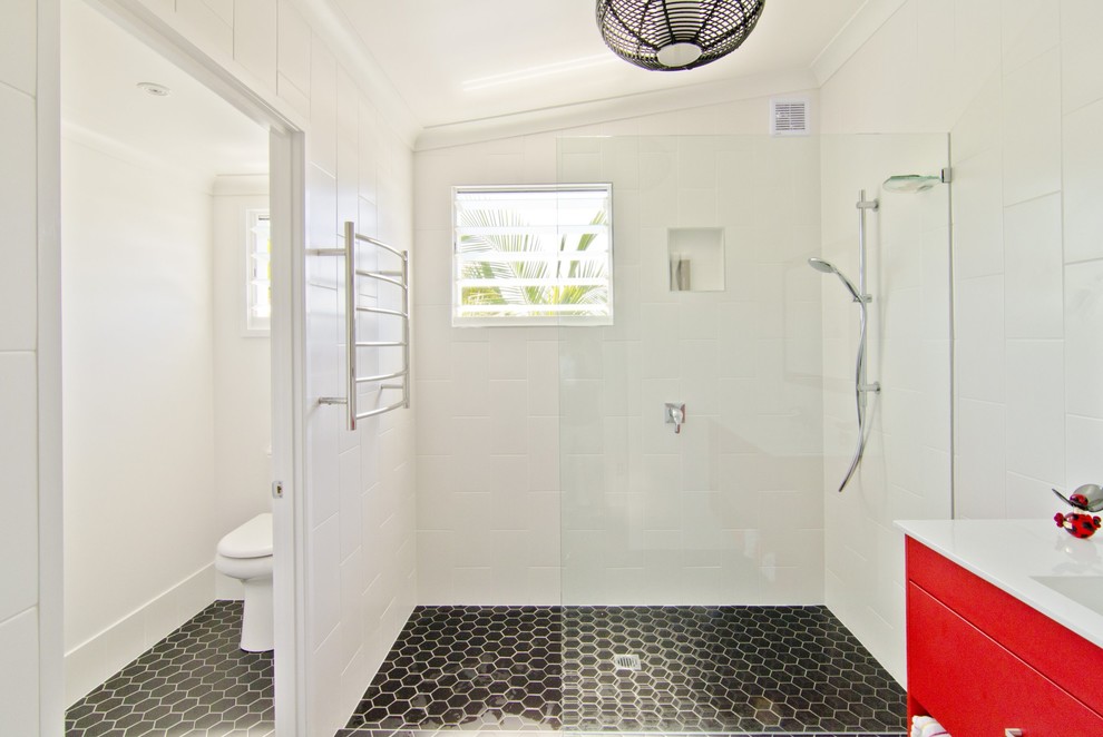 Пример оригинального дизайна: маленькая главная ванная комната в морском стиле с монолитной раковиной, плоскими фасадами, красными фасадами, столешницей из искусственного кварца, открытым душем, унитазом-моноблоком, белой плиткой, керамической плиткой, белыми стенами и полом из керамической плитки для на участке и в саду