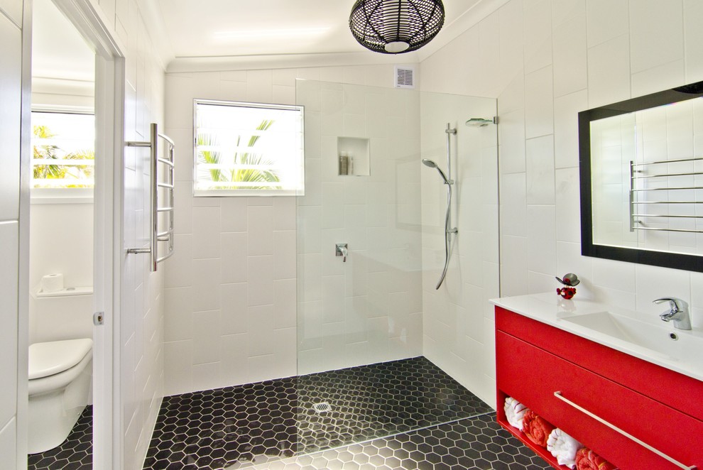 Bild på ett litet maritimt en-suite badrum, med ett integrerad handfat, släta luckor, röda skåp, bänkskiva i kvarts, en öppen dusch, en toalettstol med hel cisternkåpa, vit kakel, keramikplattor, vita väggar och klinkergolv i keramik