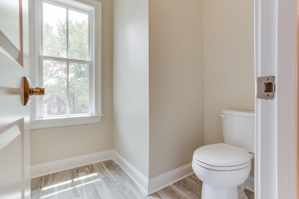 На фото: детская ванная комната в классическом стиле с врезной раковиной, светлыми деревянными фасадами, столешницей из гранита, душем над ванной, раздельным унитазом, керамической плиткой, бежевыми стенами, полом из керамической плитки и ванной в нише с