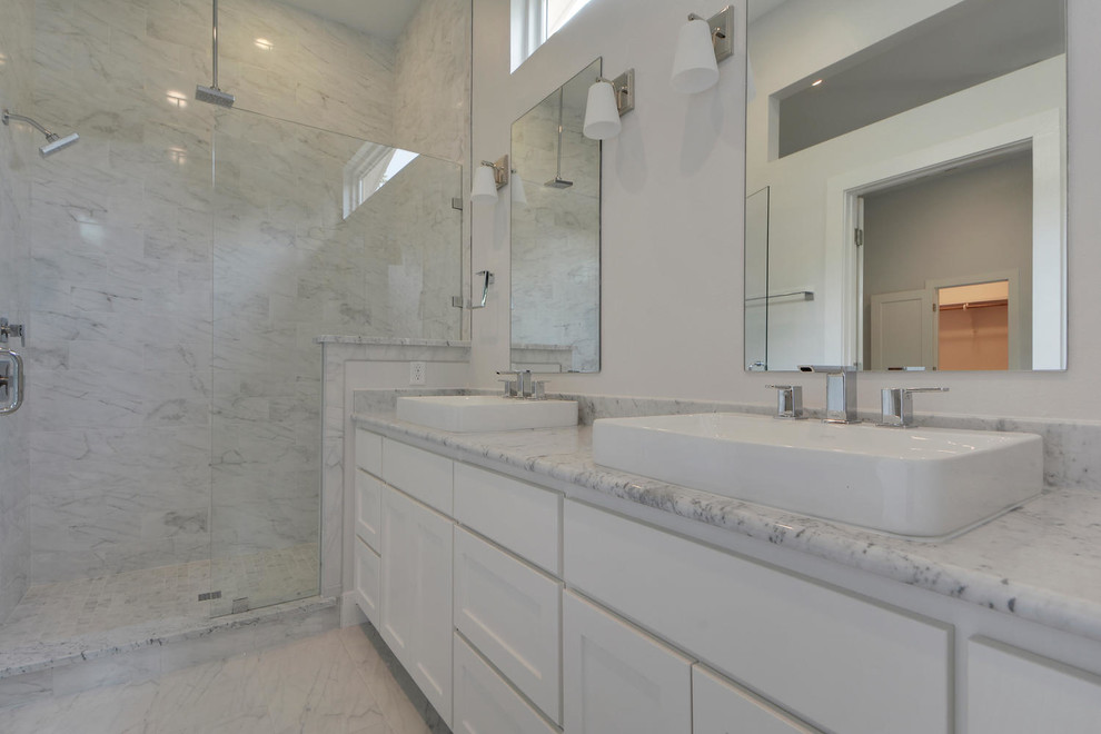 Пример оригинального дизайна: главная ванная комната среднего размера в стиле модернизм с настольной раковиной, фасадами в стиле шейкер, белыми фасадами, мраморной столешницей, угловым душем, унитазом-моноблоком, серой плиткой, каменной плиткой, белыми стенами и мраморным полом