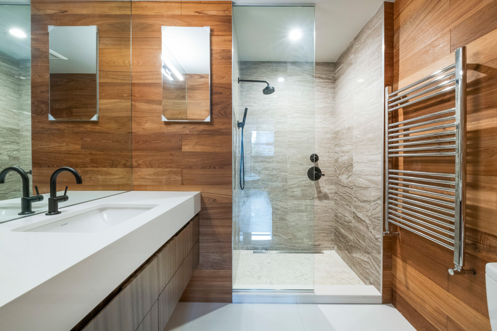 Modernes Badezimmer mit flächenbündigen Schrankfronten, hellbraunen Holzschränken, Duschnische, beigen Fliesen, Unterbauwaschbecken, weißem Boden und weißer Waschtischplatte in New York