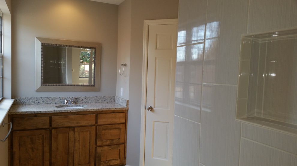 Cette photo montre une salle de bain rétro en bois brun avec un placard à porte shaker, une baignoire posée, un carrelage multicolore, des carreaux de porcelaine, un sol en carrelage de porcelaine, un plan de toilette en granite et un lavabo encastré.
