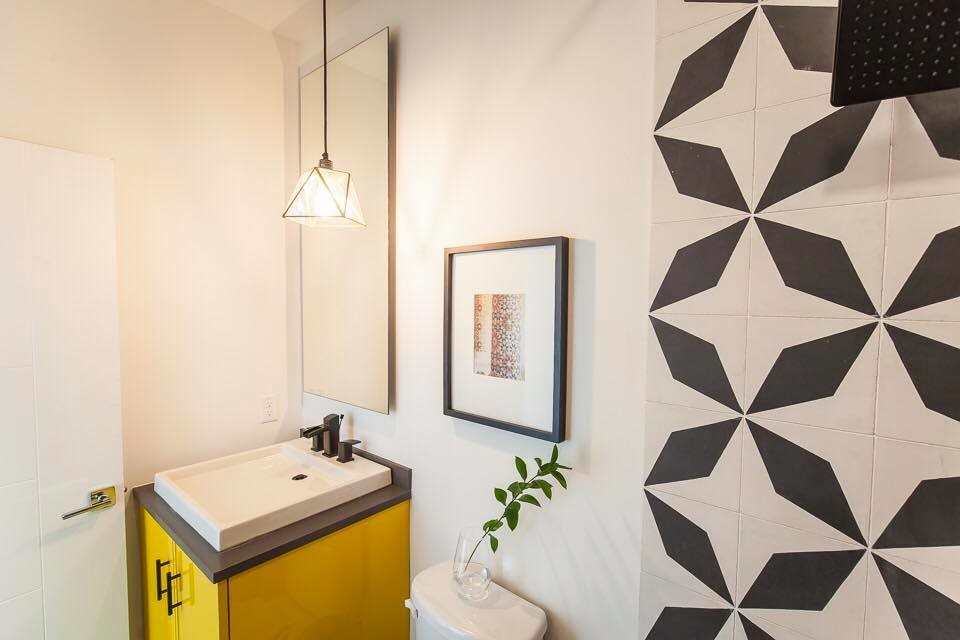 Kleines Modernes Duschbad mit flächenbündigen Schrankfronten, gelben Schränken, Wandtoilette mit Spülkasten, schwarz-weißen Fliesen, Keramikfliesen, weißer Wandfarbe, Betonboden, Einbauwaschbecken und Quarzit-Waschtisch in Austin