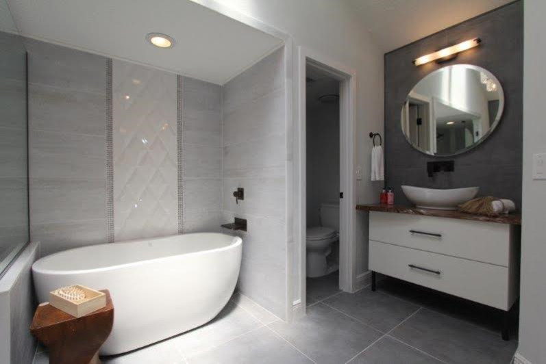 Inspiration for a large modern ensuite bathroom in Orlando with flat-panel cabinets, white cabinets, a freestanding bath, a corner shower, a one-piece toilet, grey tiles, ceramic tiles, grey walls, ceramic flooring, a vessel sink and wooden worktops.