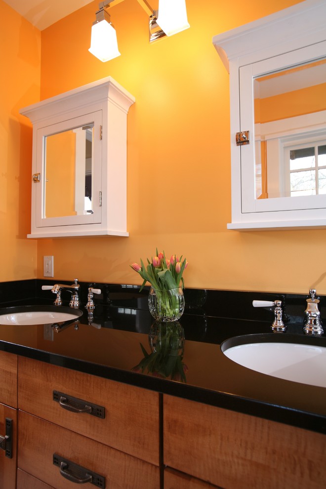 Imagen de cuarto de baño clásico con puertas de armario de madera oscura y parades naranjas