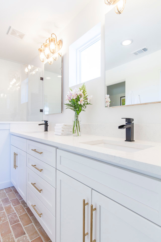 Foto de cuarto de baño principal tradicional renovado grande con armarios estilo shaker, puertas de armario blancas, ducha empotrada, paredes blancas, suelo de ladrillo, lavabo bajoencimera y encimera de cuarzo compacto