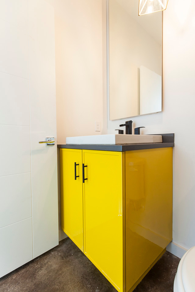 Стильный дизайн: ванная комната среднего размера в стиле неоклассика (современная классика) с фасадами в стиле шейкер, желтыми фасадами, раздельным унитазом, белыми стенами, бетонным полом, накладной раковиной, столешницей из искусственного кварца, ванной в нише и душем над ванной - последний тренд