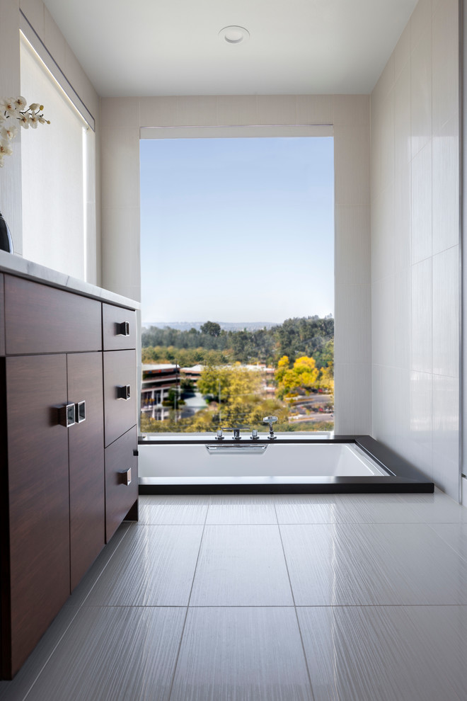 Medium sized contemporary sauna bathroom in Seattle with flat-panel cabinets, dark wood cabinets, a built-in bath, a two-piece toilet, grey tiles, white walls, ceramic flooring, a submerged sink and engineered stone worktops.