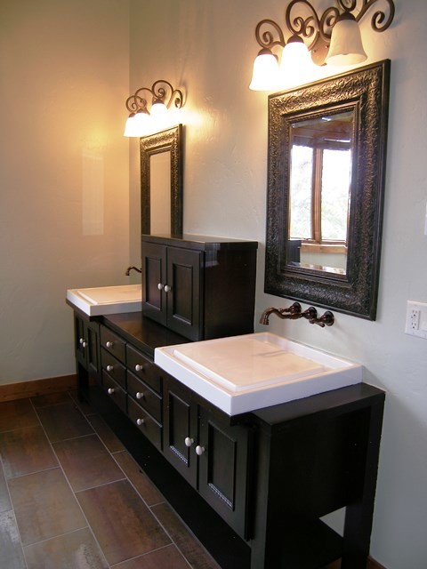 Imagen de cuarto de baño principal rústico de tamaño medio con lavabo suspendido, armarios tipo mueble, puertas de armario negras, encimera de granito, bañera esquinera, baldosas y/o azulejos de porcelana y paredes blancas
