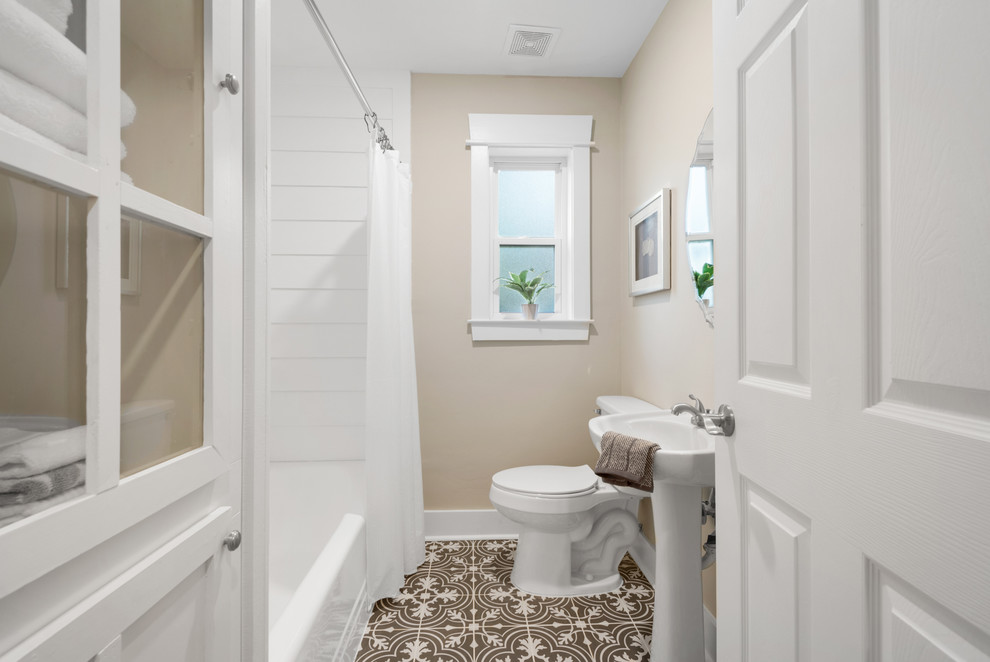 Design ideas for a rural shower room bathroom in Miami with an alcove bath, a shower/bath combination, a two-piece toilet, beige walls, a pedestal sink, multi-coloured floors and a shower curtain.