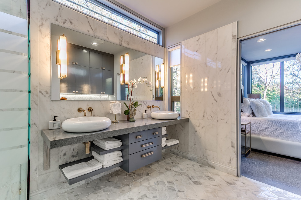 Inspiration for a contemporary ensuite bathroom in Oklahoma City with flat-panel cabinets, blue cabinets, grey tiles, white tiles, marble tiles, grey walls, marble flooring, a vessel sink, engineered stone worktops and grey floors.