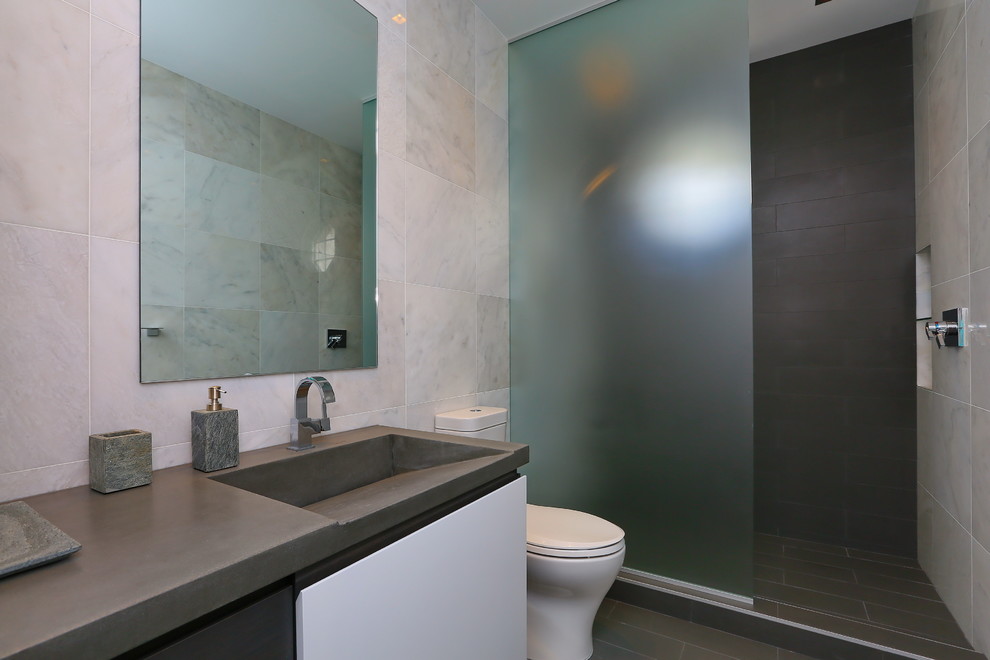 На фото: ванная комната в современном стиле с монолитной раковиной, плоскими фасадами, белыми фасадами, столешницей из бетона, открытым душем, серой плиткой, каменной плиткой и открытым душем