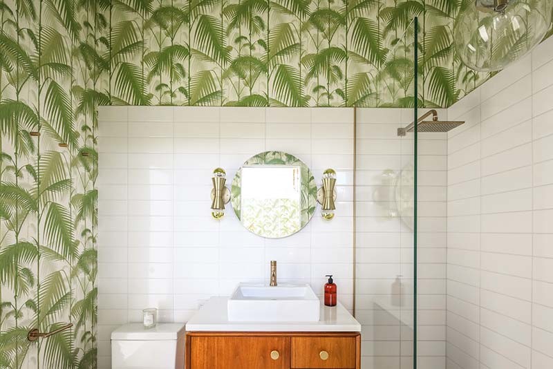 Idées déco pour une salle d'eau rétro en bois clair de taille moyenne avec un placard à porte plane, une douche ouverte, un carrelage blanc, des carreaux de porcelaine, un mur vert, une vasque et un plan de toilette en surface solide.