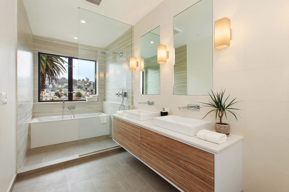 Cette image montre une salle de bain design en bois brun avec une vasque, un placard à porte plane, une baignoire en alcôve, une douche ouverte et un carrelage beige.