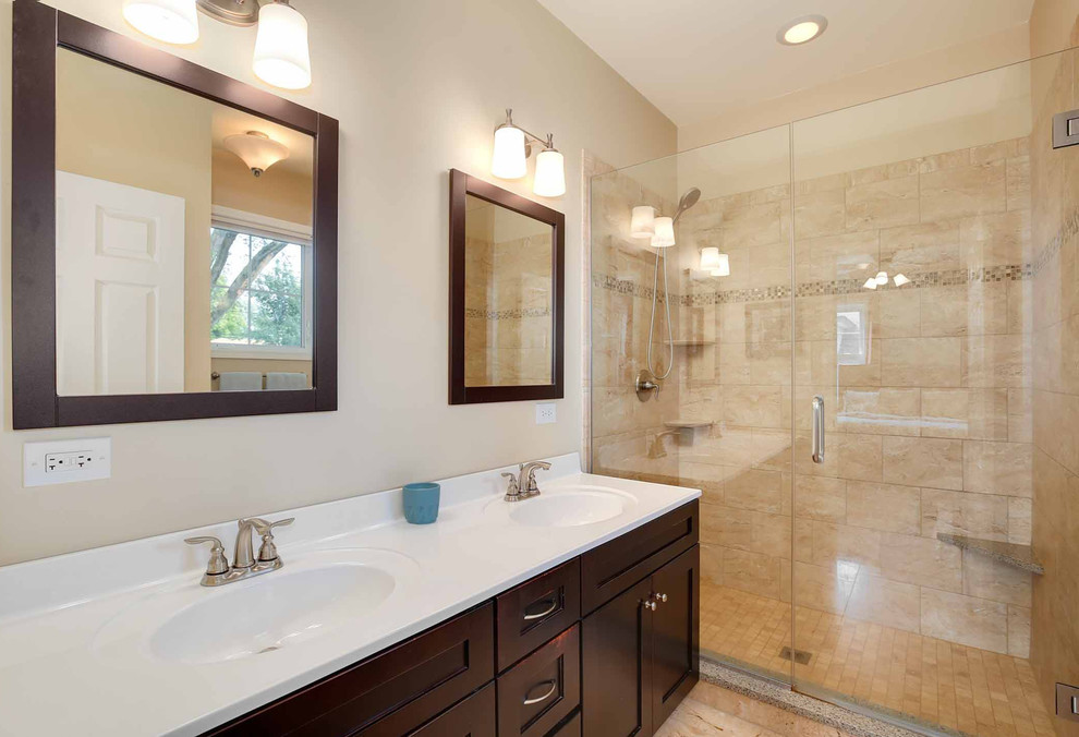 Photo of a medium sized traditional grey and brown ensuite bathroom in Chicago with shaker cabinets, dark wood cabinets, an alcove shower, a two-piece toilet, beige tiles, ceramic tiles, beige walls, cement flooring, an integrated sink, solid surface worktops, beige floors, a hinged door, white worktops, double sinks, a wallpapered ceiling and wallpapered walls.