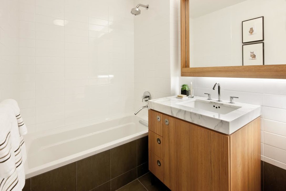 Idéer för mellanstora funkis badrum med dusch, med släta luckor, skåp i mellenmörkt trä, ett badkar i en alkov, en dusch/badkar-kombination, vit kakel, keramikplattor, vita väggar, klinkergolv i porslin, ett undermonterad handfat, marmorbänkskiva, grått golv och med dusch som är öppen