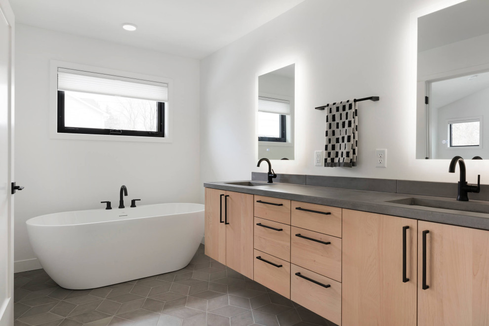 Inredning av ett modernt mellanstort grå grått en-suite badrum, med skåp i ljust trä, ett fristående badkar, vita väggar, brunt golv och ett undermonterad handfat