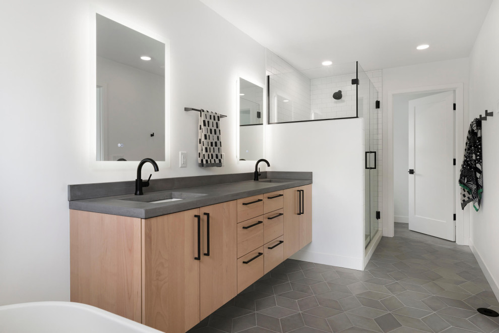 Mittelgroßes Modernes Badezimmer En Suite mit hellen Holzschränken, freistehender Badewanne, weißer Wandfarbe, braunem Boden, grauer Waschtischplatte, Doppelwaschbecken und schwebendem Waschtisch in Minneapolis