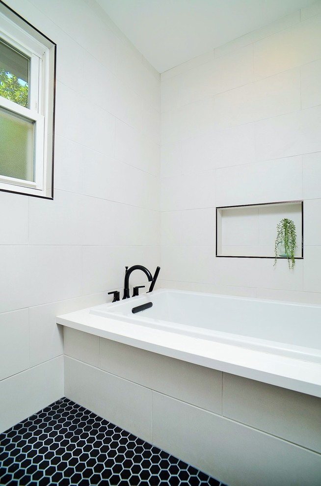 Aménagement d'une salle de bain moderne en bois brun avec un placard à porte plane, une baignoire encastrée, un espace douche bain, WC à poser, un carrelage blanc, des carreaux de porcelaine, un mur blanc, un sol en carrelage de porcelaine, une vasque, un plan de toilette en quartz modifié, un sol noir, une cabine de douche à porte battante et un plan de toilette blanc.