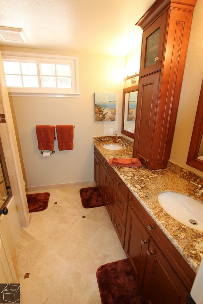 Inredning av ett klassiskt stort en-suite badrum, med ett undermonterad handfat, luckor med infälld panel, skåp i mörkt trä, granitbänkskiva, ett platsbyggt badkar, en dusch/badkar-kombination, en toalettstol med separat cisternkåpa, beige kakel, porslinskakel, beige väggar och klinkergolv i porslin