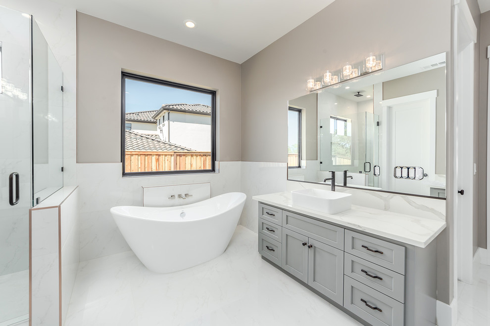Photo of a small contemporary ensuite bathroom in Sacramento with flat-panel cabinets, grey cabinets, a freestanding bath, an alcove shower, a one-piece toilet, grey tiles, ceramic tiles, white walls, marble flooring, an integrated sink, marble worktops, white floors, an open shower and grey worktops.