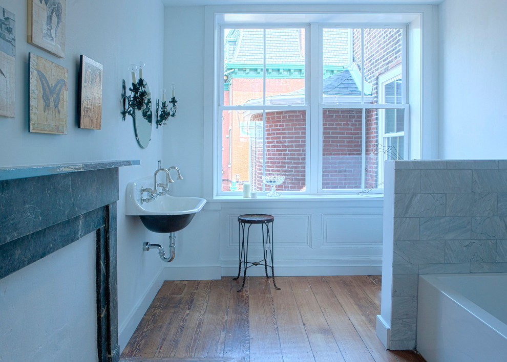 Mid-sized eclectic white tile and stone tile medium tone wood floor bathroom photo in Philadelphia with a wall-mount sink and white walls
