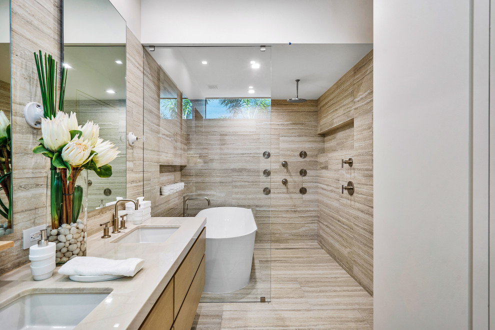 Стильный дизайн: огромная ванная комната в современном стиле с бежевыми фасадами, отдельно стоящей ванной, открытым душем, бежевой плиткой, мраморной плиткой, белыми стенами, мраморным полом, монолитной раковиной, мраморной столешницей, бежевым полом, открытым душем, белой столешницей, тумбой под две раковины и подвесной тумбой - последний тренд