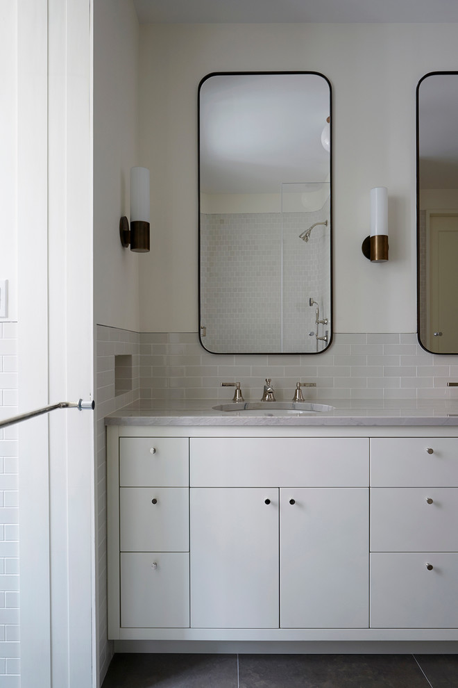 Стильный дизайн: ванная комната в стиле модернизм с плоскими фасадами, белыми фасадами, серой плиткой, белыми стенами, врезной раковиной и столешницей из кварцита - последний тренд