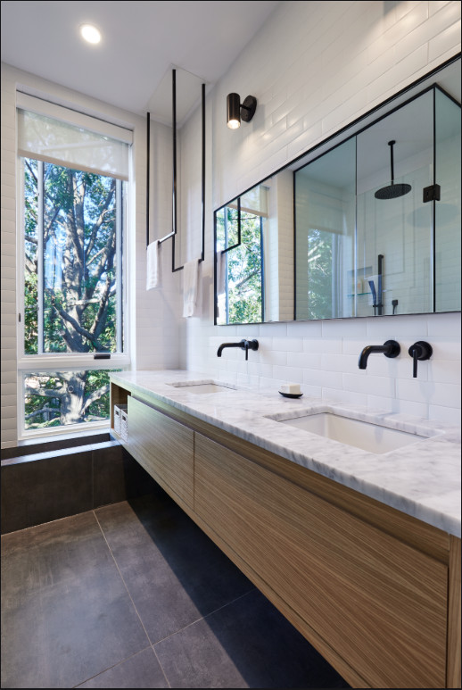 Medium sized contemporary ensuite bathroom in New York with flat-panel cabinets, medium wood cabinets, a built-in shower, white tiles, metro tiles, white walls, slate flooring, a submerged sink, marble worktops, grey floors, an open shower and white worktops.