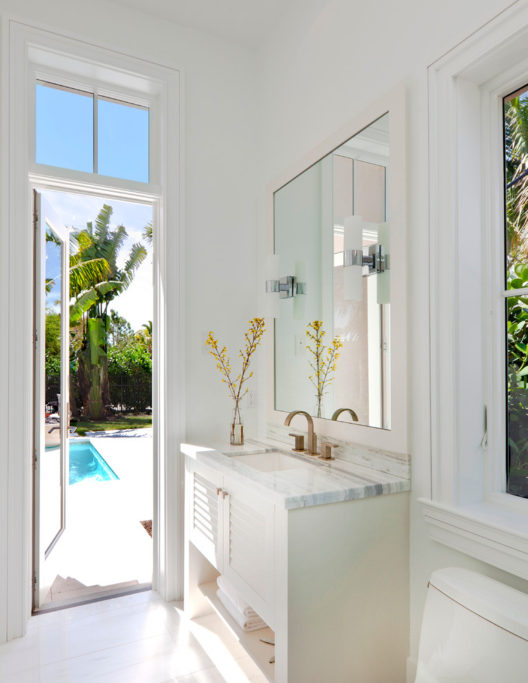 Idée de décoration pour une salle de bain tradition avec un placard à porte persienne, des portes de placard blanches et un mur blanc.