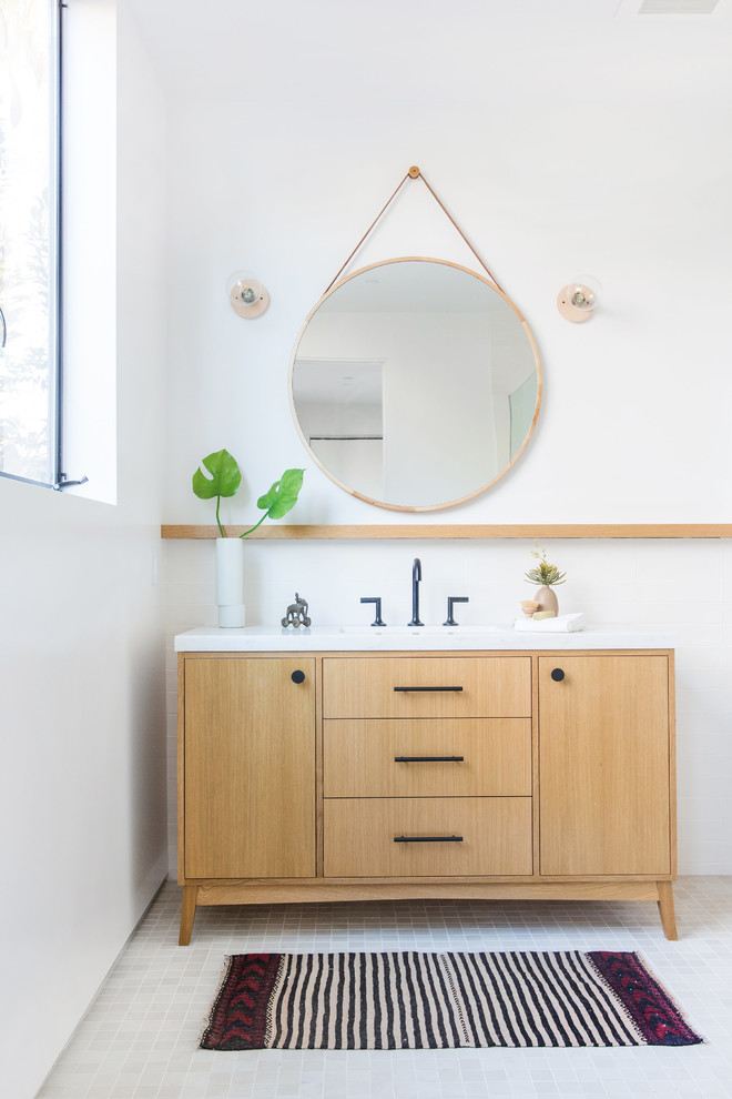 Modernes Badezimmer mit hellen Holzschränken, weißer Wandfarbe, grauem Boden, weißer Waschtischplatte und flächenbündigen Schrankfronten in Los Angeles
